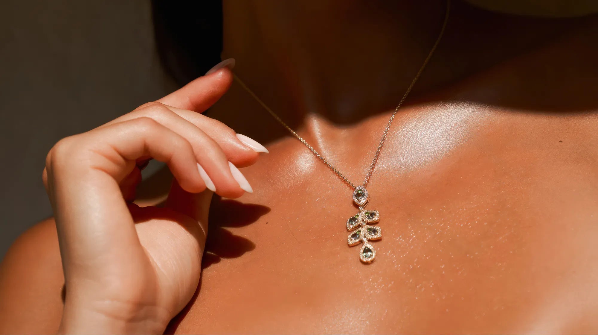 Necklace with a leaf-shaped pendant worn by a person